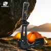 Schwarze HX OUTDOORS DC53 Camping-Axt auf Felsen vor Zelten im Sonnenuntergang für Outdoor- und Bushcraft-Einsatz