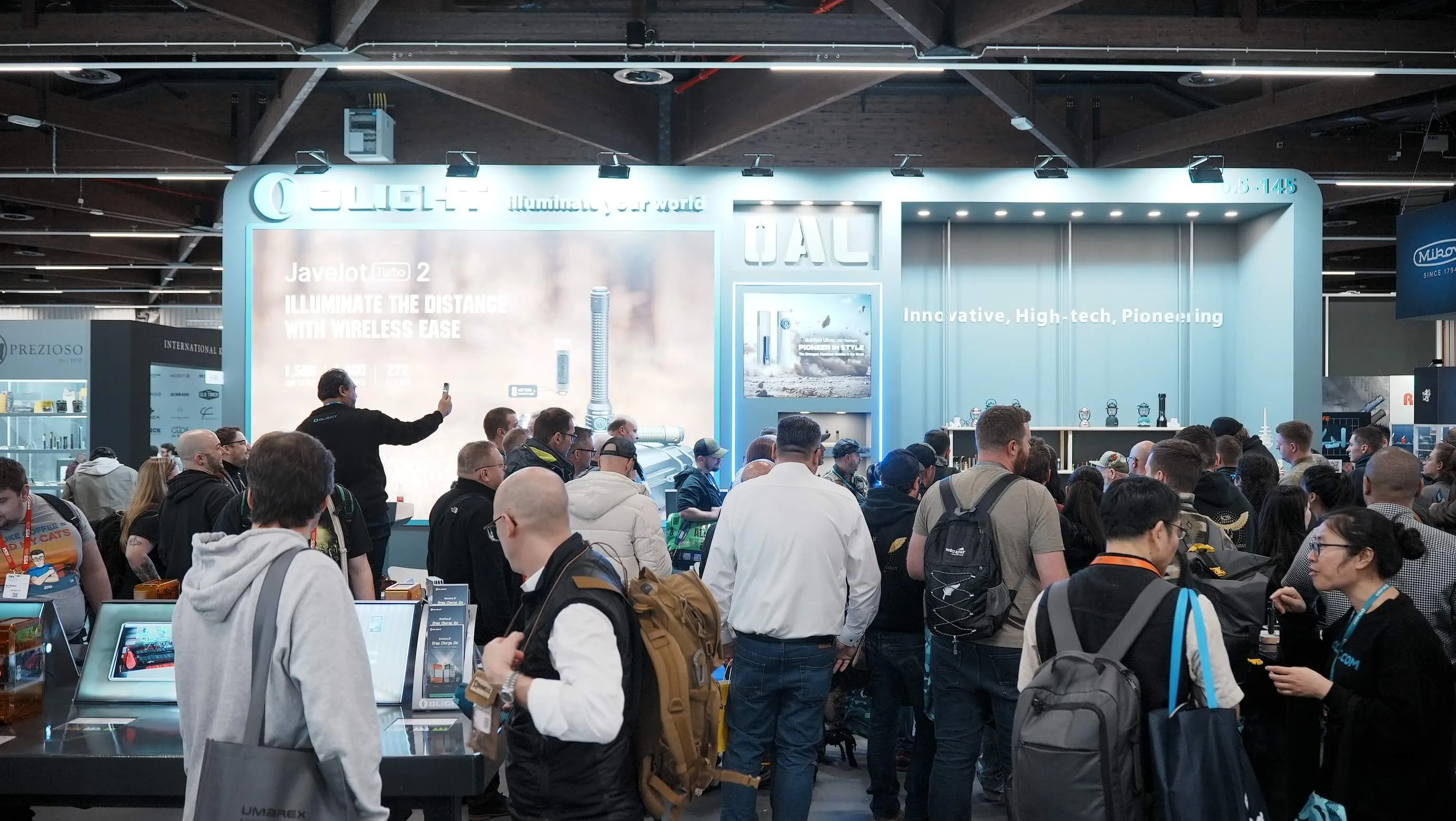 Messebesucher versammeln sich an einem Stand mit Technologieprodukten, während Präsentationen und interaktive Displays gezeigt werden.