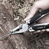Hand mit NexTool W40 Multitool schneidet Draht an einem Baumstamm im Freien