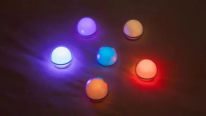 Sechs farbige LED-Leuchtkugeln auf dunklem Hintergrund, die stimmungsvolles Licht erzeugen.