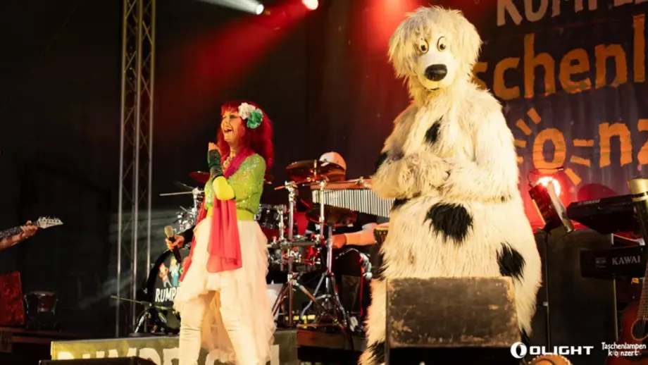 Rotschopf-Sängerin & Hundemaskottchen auf RUMPELSTILZ-Bühne beim Taschenlampenkonzert.
