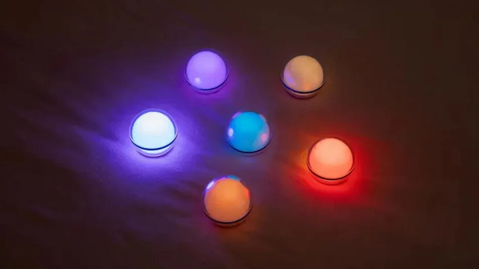 Bunte LED-Leuchtkugeln erzeugen stimmungsvolle Lichtakzente auf dunklem Grund.