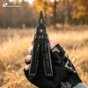 Schwarzes HX Outdoors Multitool mit Zange in Hand mit Tarnhandschuh vor herbstlichem Waldhintergrund