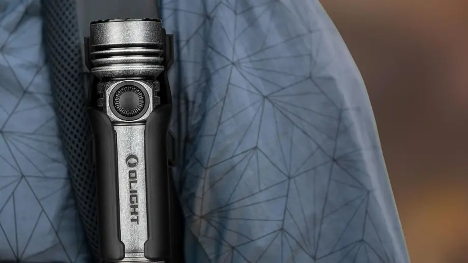 Olight LED-Taschenlampe für Outdoor, am Rucksackriemen befestigt.