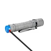 Graue Olight Warrior Mini LED-Taschenlampe mit Gravur beim Laden über magnetisches Ladekabel auf weißem Hintergrund