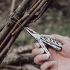 NexTool Multitool-Zange schneidet Metalldraht an zusammengebundenen Ästen beim Camping im Freien