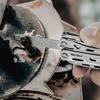 NexTool Multitool nutzt die integrierte Metallfeile an einer verrosteten Schraube im Außenbereich.