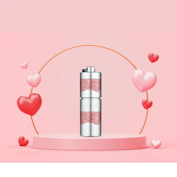 Olight I1R 2 Pro Silber Schlüsselbund-Taschenlampe mit Wellenmuster auf rosa Valentinstags-Podest, Geschenkidee.