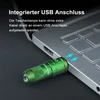 Grüne Taschenlampe mit USB-Anschluss, direkt an Laptop zum Aufladen angeschlossen.