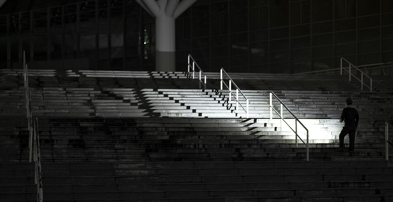Erwachsene Person nutzt Olight iUltra EOS zur Orientierung auf einer dunklen Treppe