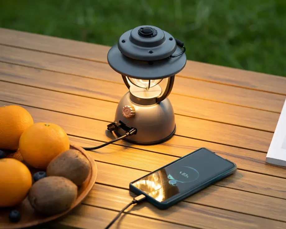 Olantern Classic 2 Pro leuchtet auf einem Tisch und l&auml;dt ein Smartphone