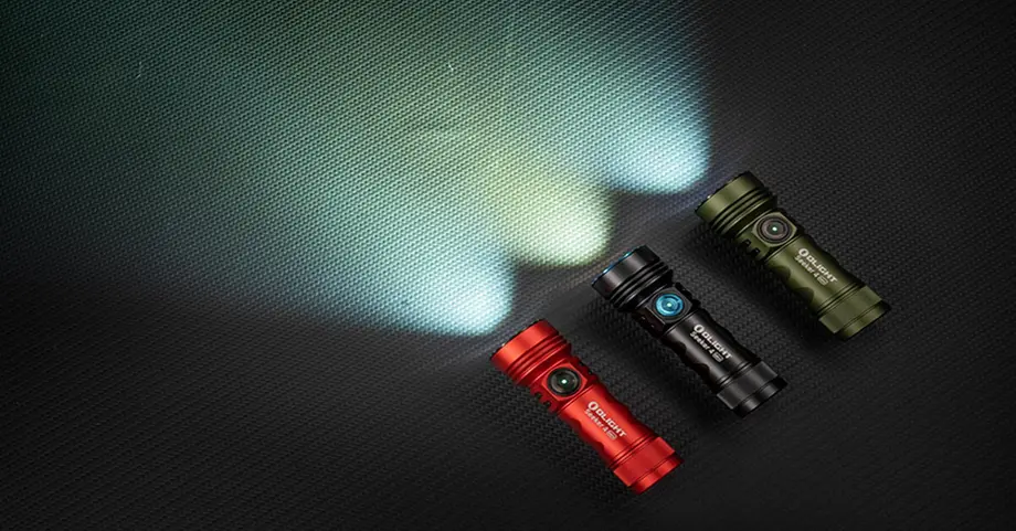 Drei Taschenlampen in Rot, Schwarz und Grün leuchten auf einem dunklen Hintergrund.